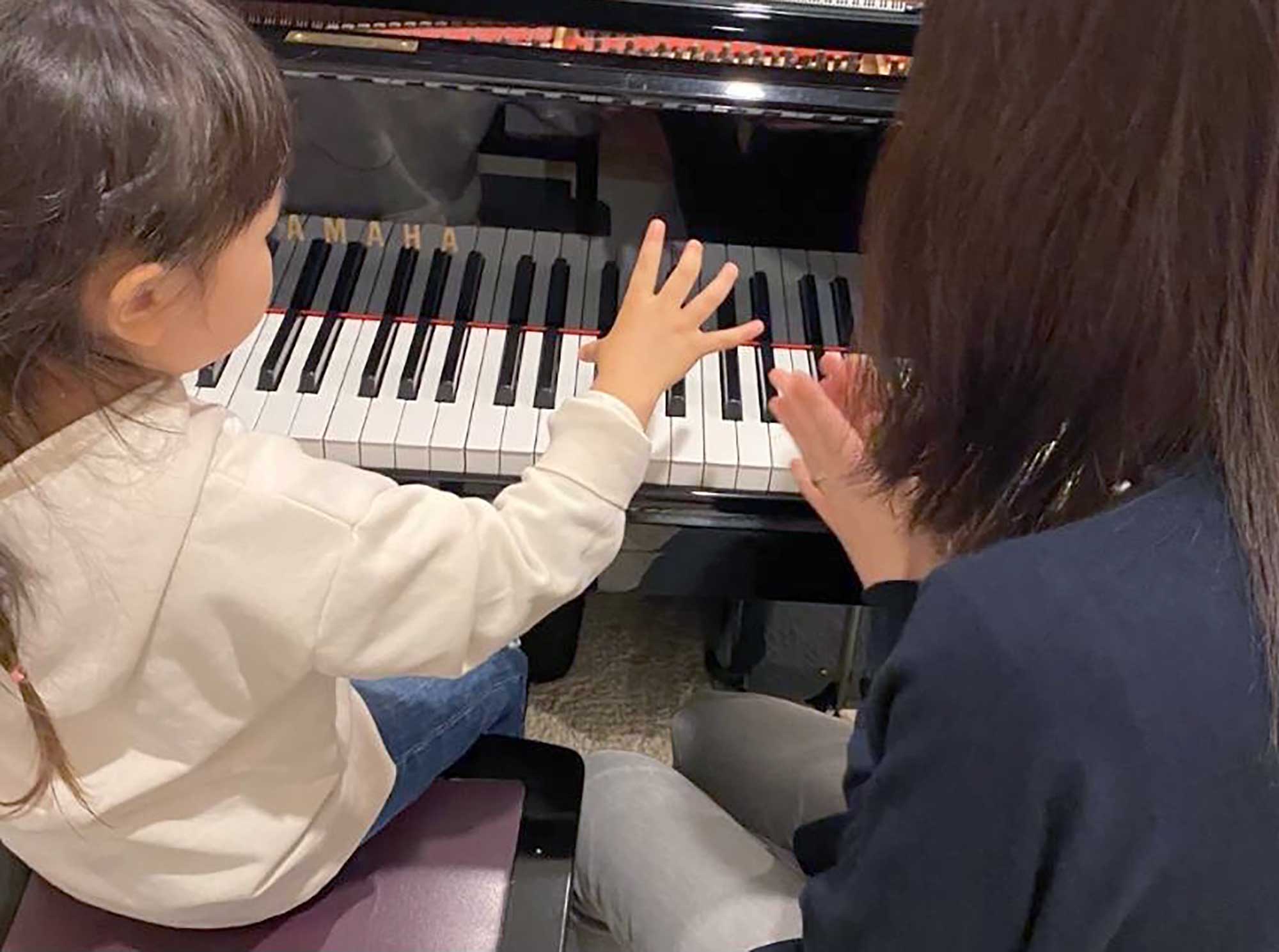 講師と一緒にピアノに向かうレッスンの様子